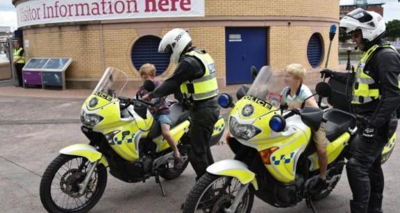 Officer showing motorbike with child