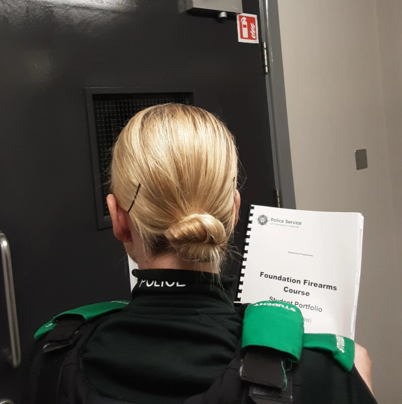 Student Officer holding firearms training booklet