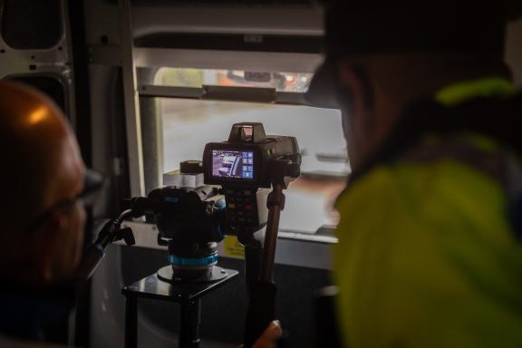 A close-up view of a person operating a speed radar device inside a vehicle