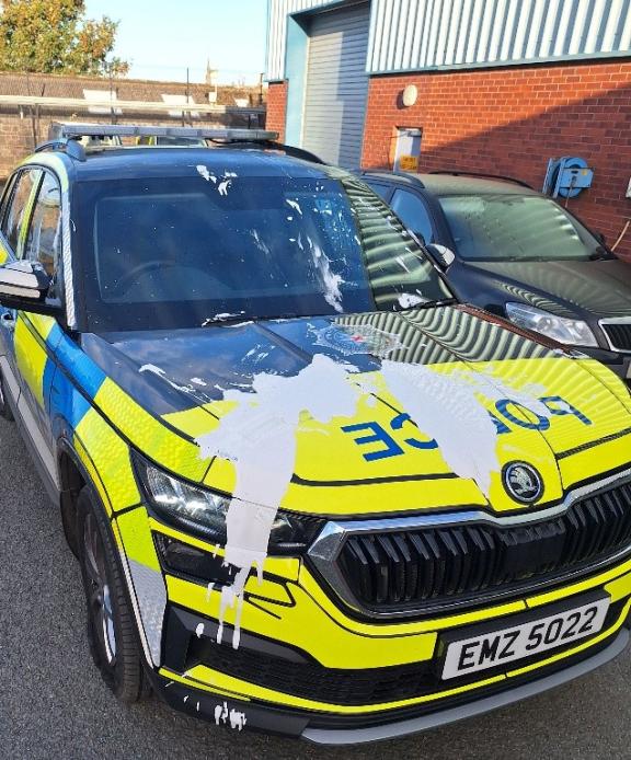 Damaged police car with slashed tyre