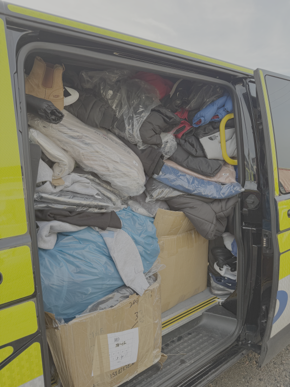 Police van with side door open and filled with seized counterfeit goods.