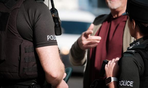 Two Police Officers interacting with a member of the public.
